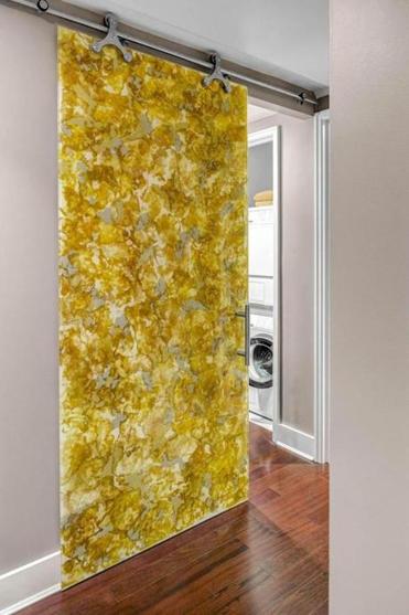 Our custom-designed barn door is dramatic and practical. The painted glass panel doubles as a work of art in the hallway, where the homeowner's collection of contemporary art is on display.