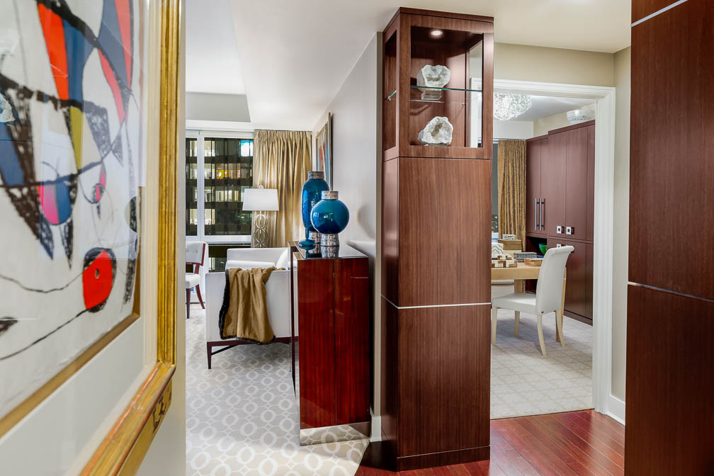 This is a wonderful view from the hall and entry into this luxury condo in Manhattan.  It is one of our absolute favorite interiors we designed.  You can see the new rosewood custom cabinets we added, when we gave this lovely home a makeover. We desired a minimalist look for the new storage.